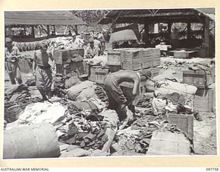 MUSCHU ISLAND, NEW GUINEA. 1945-10-10. JAPANESE TROOPS WITH THE NEWLY ARRIVED SHIPMENT OF JAPANESE STORES AND CLOTHING FROM THEIR HEADQUARTERS AT RABAUL. THEY ARE SORTING THE CLOTHING WHICH THEY ..