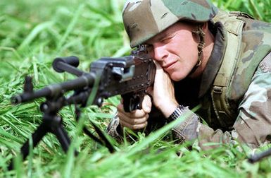 US Marine Corporal (CPL) Bradley Lincoln aims his M240G machine gun while on guard duty at Kaneohe Bay Marine Corps Station, HI. Marines from the 11th Marine Expeditionary Unit (MEU) Camp Pendleton, CA practice simulated Noncombatant Evacuation Exercises (NEO) during Operation RIMPAC 96