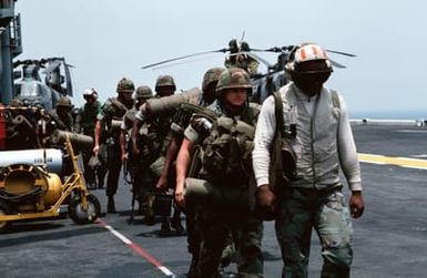 Marines of the 22nd Marine Expeditionary Unit (22nd MEU) are led aboard the amphibious assault ship USS SAIPAN (LHA 2) during Operation Sharp Edge. The Marines will be flown to the U.S. Embassy in Monrovia, Liberia, to augment security and evacuate U.S. and foreign nationals from the fighting between government and rebel forces