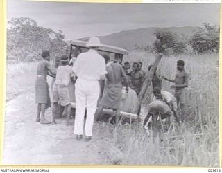 PORT MORESBY - NATIVES EXTRICATING LORRY FROM BOG ON ROADSIDE NEAR SAPPHIRE CREEK, N. GUINEA. WHITE MAN IS ONE R. CHANT, MINE MANAGER OF MANDATED ALLUVIALS, PORT MORESBY. (NEGATIVE BY N. TRACY)