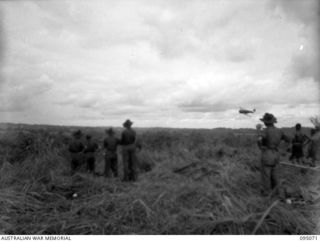 KIARIVU, NEW GUINEA, 1945-08-06. AN RAAF AIRCRAFT CIRCLES DOWN CLOSE TO TROOPS OF 2/7 INFANTRY BATTALION WHO ARE ON A TREK FROM BERIMU TO THE KIARIVU AREA DURING A SIX DAY PATROL INTO ENEMY ..