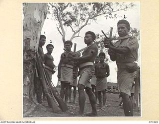 BISIATABU, NEW GUINEA. 1944-05-23. NATIVE TROOPS OF THE PAPUAN INFANTRY BATTALION PARTICIPATING IN A TRAINING EXERCISE ON THE OWEN GUN. THE NATIVES QUICKLY ADJUST TO THE USE OF MODERN WEAPONS. ..