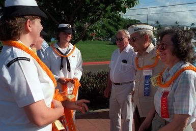 Irvin and Elisie Obermeyer are greeted by Cryptologic Technician O (Communications) 2nd Class Jeanine Silva, left, and Data Processing Technician/SEAMAN Jeana Matheson upon arrival at the Visitors Center. Mr. Obermeyer, a survivor of the Japanese attack on Pearl Harbor, will be attending the observance commemorating the 50th anniversary of the event