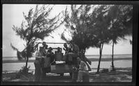 [Servicemen and military truck on beach]