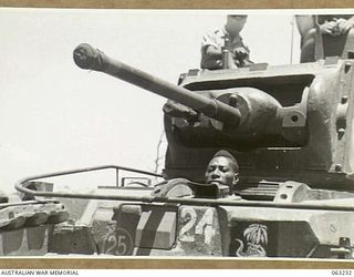SOUTHPORT, QLD. 1944-01-18. A NEW GUINEA POLICE BOY IN THE DRIVERS COMPARTMENT OF A MATILDA TANK OF THE 4TH ARMOURED BRIGADE