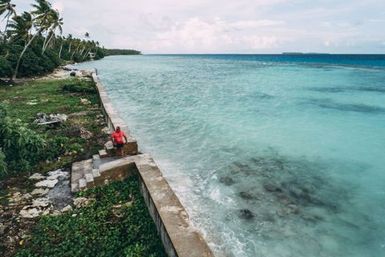 Co-collector Atonio Tuia sitting on sea wall, Nukunonu, Tokelau