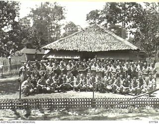 LAE BASE AREA, NEW GUINEA. 1944-12-24. PERSONNEL OF THE TRANSPORT SECTION, HEADQUARTERS, FIRST AUSTRALIAN ARMY OUTSIDE THEIR MESS WHICH WON THE SECOND PRIZE IN THE COMPETITION FOR THE BEST ..