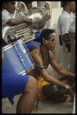 Samoan dancer resting beside Samoan Brass Band at the 7th Festival of Pacific Arts, Apia, Samoa