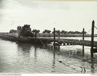 BOUGAINVILLE ISLAND. 1944-12-06. TRUCKS CARRYING MEMBERS OF THE 15TH INFANTRY BATTALION CROSS THE PONTOON BRIDGE BUILT BY THE TROOPS OF THE 5TH FIELD COMPANY, OVER THE REINI RIVER DURING THEIR ..
