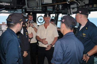 Russian Federation Navy Captain (CAPT) Andrey Shuvalov speaks with US Navy (USN) Officers, during his visit to the bridge of the USN Ticonderoga Class Guided Missile Cruiser (Aegis) USS COWPENS (CG 63), during the opening phases of a joint US-Russian Naval Exercise. A Russian Federation Navy vessel made the first visit to the US Territory of Guam in order to participate in a joint humanitarian assistance and disaster relief exercise