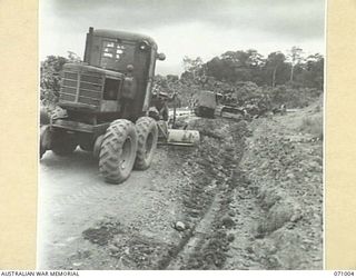 LAE - NADZAB ROAD, NEW GUINEA. 1944-03-09. GRADERS AND ANGLE DOZERS WIDENING THE ROAD ABOUT TEN MILES FROM LAE