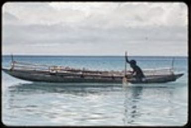 Canoes: man paddles fishing canoe