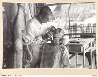 PIEDU ISLAND, SOLOMON ISLANDS. 1945-11-13. A JAPANESE DENTIST WORKING ON A PATIENT IN HIS SURGERY IN JAPANESE AREA 10. JAPANESE CONCENTRATED ON THE ISLAND ARE UNDER THE CONTROL OF 7 INFANTRY ..