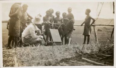 Cannibals were most interested in the gramaphone and said that there must be a "master stop along bokis", Bulolo, Papua New Guinea, ca. 1933 / Mr. Sturkey