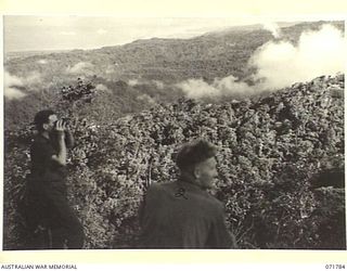 Wareo, New Guinea, 1944-03-29. The view from B Company, 4th Field Ambulance rest camp overlooking a recent battle ground; Finschhafen and Langemak Bay in the background. Identified personnel are: ..