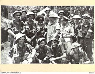 1942-10-08. THE COMMANDER-IN-CHIEF, GENERAL SIR THOMAS BLAMEY AND MAJOR GENERAL ALLEN WITH A GROUP OF INFANTRYMEN JUST RETURNED FROM A PATROL IN FORWARD AREAS. THE NATIVE IN THE CENTRE OF THE GROUP ..