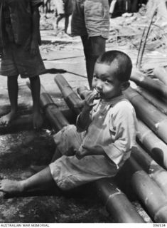 RABAUL AREA, NEW BRITAIN. 1945-09-13. CHINESE CIVILIANS, INTERNED BY THE JAPANESE AT A CAMP 15 MILES WEST OF RABAUL, WERE CONTACTED BY A PARTY OF AUSTRALIAN ARMY AND RED CROSS OFFICIALS SOON AFTER ..