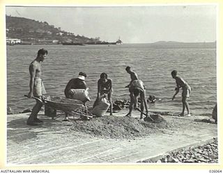 PAPUA, NEW GUINEA. 1942-07-27. PERSONNEL OF THE MARINE SECTION, ROYAL AUSTRALIAN AIR FORCE MIXING CONCRETE IN THE CONSTRUCTION OF A SLIPWAY AT THEIR SEAPLANE BASE