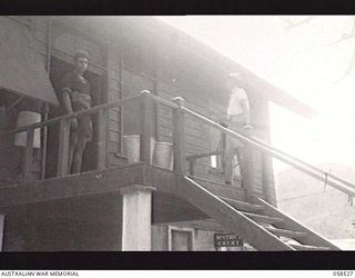 HANUABADA, NEW GUINEA. 1943-10-23. THE DISTRICT OFFICER OF THE AUSTRALIAN NEW GUINEA ADMINISTRATIVE UNIT WHICH IS CHARGED WITH THE ADMINISTRATION OF THE NATIVE POPULATION, ON THE BALCONY OF HIS ..