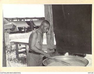 BOUGAINVILLE. 1945-09-28. JAPANESE SOLDIER PREPARING RICE IN A POT FOR SICK AND WOUNDED PATIENTS WHO ARE BEING CARED FOR BY JAPANESE MEDICAL OFFICIALS UNDER 7 FIELD AMBULANCE SUPERVISION