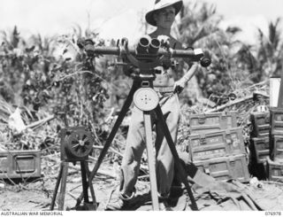 JACQUINOT BAY, NEW BRITAIN. 1944-11-17. VX126067 GUNNER R.V. HOGAN, SPOTTER, 472ND HEAVY ANTI-AIRCRAFT TROOP, WITH HIS TELESCOPE AND HAND ALARM