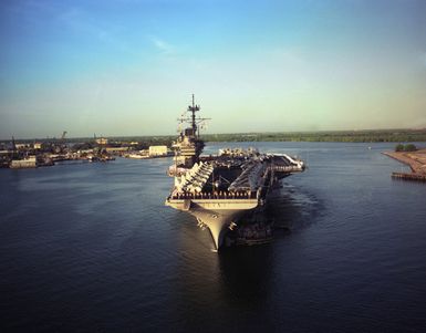 An aerial bow view of the US Navy (USN) Forrestal Class Aircraft Carrier USS RANGER (CV 61), with her Sailors manning the rails, and aircraft of the Carrier Air Wing 2 (CVW-2) on her deck, as she is nudged by tugboats NIANTIC (YTB-781) and NEODESHA (YTB-815), on her arrival at Pearl Harbor Naval Base in Pearl Harbor, Hawaii (HI)