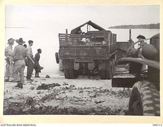 MUSCHU ISLAND, NEW GUINEA. 1945-09-11. A TRUCK COMING OFF A BARGE WITH A DAY'S RATIONS FOR 1,500 PERSONNEL. THE RATIONS ARE RICE, TEA, SUGAR, BULLY BEEF AND AN ISSUE OF WASHING SOAP. THE ISLAND WAS ..