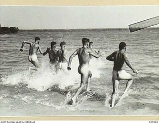 PORT MORESBY, PAPUA. 1942-07-20. AUSTRALIAN TROOPS RUSHING INTO THE SHALLOWS FOR A REFRESHING PLUNGE AFTER A DAY'S WORK