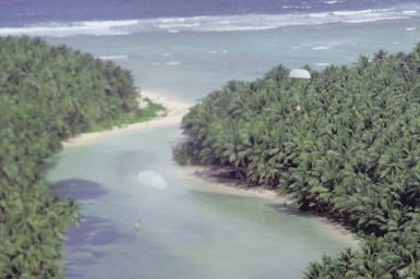 Donated Christmas gifts collected by volunteers from the 43rd Security Police Squadron, the 605th Military Airlift Support Squadron, and the 43rd Munitions Maintenance Squadron are parachuted onto an island