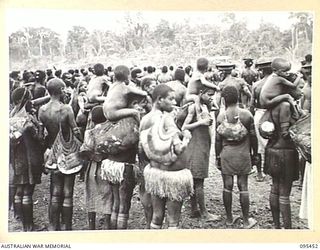 KIARIVU, NEW GUINEA, 1945-08-17. REFUGEE NATIVES LINED UP ON THE AIRSTRIP FOR COUNTING AND INSPECTION BY CAPTAIN R.R. COLE, THE ASSISTANT DISTRICT OFFICER AUSTRALIAN NEW GUINEA ADMINISTRATIVE UNIT, ..