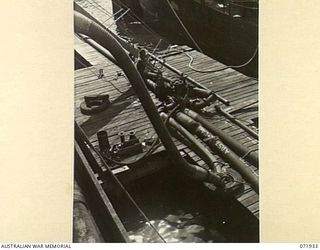 MILNE BAY, PAPUA, NEW GUINEA. 1944-04-03. A SOLDIER OPERATES A MAIN VALVE ON THE WHARF GOVERNING THE FLOW OF FUEL FROM THE OIL TANKER 'EMPIRE SILVER' TO BULK STORAGE TANKS AT THE 2ND BULK PETROLEUM ..