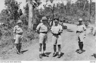 Brigadier Arnold W. Potts DSO MC (wearing cap), Commanding 21st Australian Infantry Brigade, and the Brigade Staff Officers await the arrival of Major General A S Allen CB CBE DSO VD, Commanding ..
