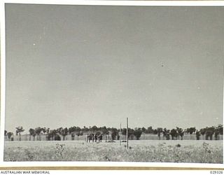 FORBES, NSW. 1943-02. "GUINEA PIGS" TAKING PART IN A GAS SHELL EXPERIMENT CAN BE SEEN (TO LEFT OF THE TWO POSTS) DASHING FROM THEIR COVER TRENCH TO THEIR STATIONS. A WHISTLE SIGNAL HAS BEEN GIVEN ..
