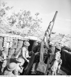 1942-11-06. SHOT OF AN AUSTRALIAN ANTI-AIRCRAFT BATTERY SOMEWHERE IN NEW GUINEA. THIS BATTERY IS MANNED ENTIRELY BY VICTORIANS USING GUNS MANUFACTURED IN A VICTORIAN FACTORY AND THEIR BAG OF ENEMY ..