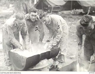 MALMAL MISSION, JACQUINOT BAY, NEW BRITAIN. 1944-11-30. TROOPS OF HEADQUARTERS, 5TH DIVISION WASHING AND STERILISING THEIR EATING UTENSILS AFTER LUNCH IN THE UNIT MESS. IDENTIFIED PERSONNEL ARE:- ..
