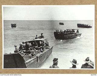 KANOMI BEACH, NEW GUINEA. 1944-01-05. TROOPS OF THE 2/23RD AUSTRALIAN INFANTRY BATTALION, 26TH AUSTRALIAN INFANTRY BRIGADE, 9TH AUSTRALIAN DIVISION ABOARD BARGES WHICH ARE TO TAKE THEM UP THE COAST ..