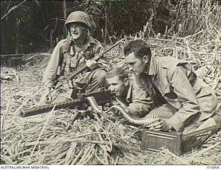 Outside Lae, New Guinea. 1943. American paratroopers Lieutenant (Lt) Joe Phelan of Grand Island, Nebraska, Corporal (Cpl) Casey Kalowski of Buffalo, New York and Private (Pte) F. Summer of ..