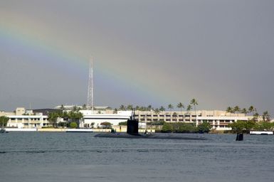 A quarter port stern view of the US Navy (USN) Los Angeles Class Attack Submarine USS COLUMBIA (SSN 771), showing Sailor manning a topside watch as it exits the harbor at Navy Base (NB) Pearl Harbor, Hawaii (HI) for the start of the Rim of the Pacific (RIMPAC) 2006 Exercises. RIMPAC is the largest biennial maritime exercise, which brings together military forces from Australia, Canada, Chile, Peru, Japan, the Republic of Korea, the United Kingdom and the US. A rainbow sky in visible in the background.'