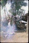 Akis (left) hangs up clothing and fabrics which he has purchased on a trip to Madang