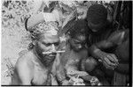 Pfun, a luluai, and children examine photographs