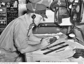 Qld. 1944-09-24. Navigator of Martin PBM Mariner flying boat aircraft, serial no. A70-5, registration VHCPE, of No. 41 (Transport Sea) Squadron RAAF stationed at Cairns, in flight to Port Moresby. ..