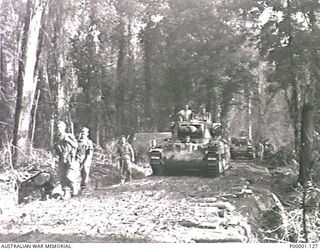 THE SOLOMON ISLANDS, 1945-04-24/27. MATILDA TANKS OF 2/4TH AUSTRALIAN ARMOURED REGIMENT ACCOMPANIED BY AUSTRALIAN SOLDIERS MOVING ALONG A CORDUROY ROAD ON BOUGAINVILLE ISLAND. (RNZAF OFFICIAL ..