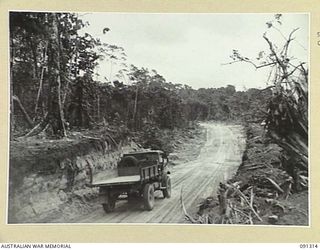 BOUGAINVILLE. 1945-04-28. CUTTING THROUGH SLATER'S KNOLL SHOWING THE 3 TONNER ROAD CONSTRUCTED BY 15 FIELD COMPANY, ROYAL AUSTRALIAN ENGINEERS, AFTER THE ACTION ON THE KNOLL BY TROOPS OF B COMPANY, ..