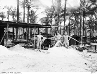 JACQUINOT BAY, NEW BRITAIN, 1945-08-15. SOLDIERS OF 39 WORKS COMPANY, ROYAL AUSTRALIAN ENGINEERS MIXING CEMENT AT THE HOSPITAL PAUSE FOR A MOMENT WHEN THE ANNOUNCEMENT OF PEACE IS MADE