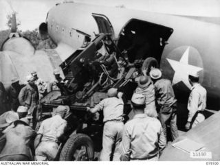 1943-06-25. NEW GUINEA. A U.S. ANTI-AIRCRAFT UNIT LOADS A 40MM BOFORS GUN INTO A DOUGLAS C47 DAKOTA TRANSPORT PLANE