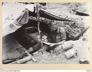 ULUPU, NEW GUINEA, 1945-07-10. PTE J.N. HARRIS, 2/5 INFANTRY BATTALION, FINDS THE TIME TO WRITE HOME FROM THE SHELTER OF HIS DUGOUT DURING A LULL IN OPERATIONS