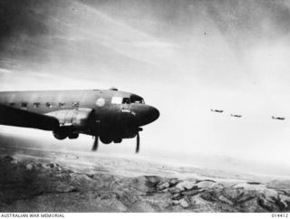 1943-03-10. NEW GUINEA. QUICK CONCENTRATION OF MEN AND GUNS BY AIR WAS RESPONSIBLE FOR THE DEFEAT OF THE JAPANESE ATTACK ON WAU. THIS PHOTO SHOWS TRANSPORT PLANES FLYING ACROSS THE MOUNTAINS ..