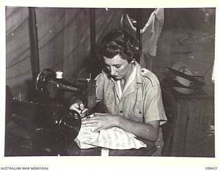 RABAUL, NEW BRITAIN. 1945-10-31. PRIVATE A. STEPHENS, AUSTRALIAN ARMY MEDICAL WOMEN'S SERVICE OF 118 GENERAL HOSPITAL HAS A FULL TIME JOB AS A SEAMSTRESS
