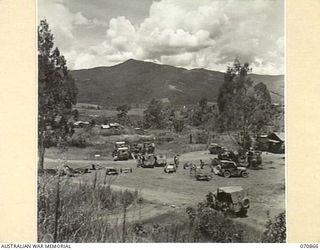WAU, NEW GUINEA, 1944-02-20. THE 2/34TH GENERAL TRANSPORT COMPANY'S CAMP SHOWING NO.1 PLATOON'S MAINTENANCE AREA. THE KUPER RANGE LIES TO THE NORTH EAST IN THE BACKGROUND BEYOND THE WAU VALLEY. THE ..