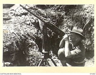 ALEXISHAFEN, NEW GUINEA. 1944-05-17. NX125296 LIEUTENANT B. MCDONAGH, 35TH INFANTRY BATTALION (1), OPERATES A CAPTURED JAPANESE AMERICAN MADE BROWNING AT THE MOUTH OF THE REMPI RIVER, NORTH OF ..